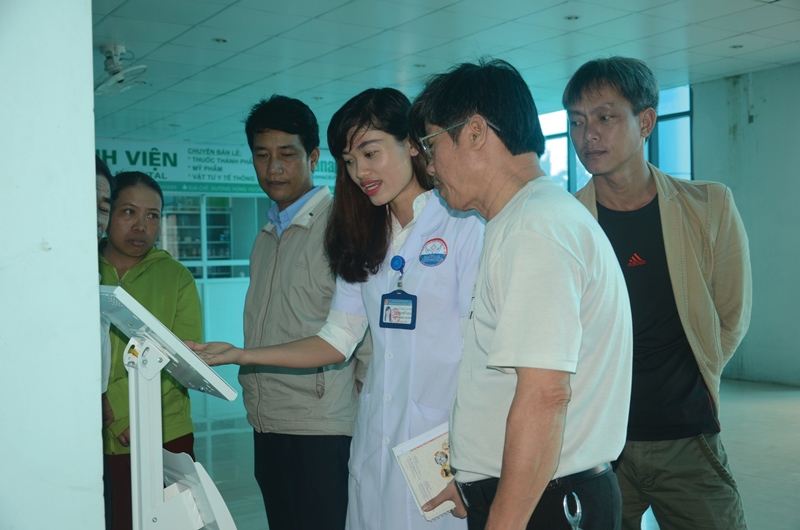 Cán bộ BVĐK tỉnh hướng dẫn người dân các thao tác thực hiện chấm điểm trên máy khảo sát nóng đặt tại bệnh viện