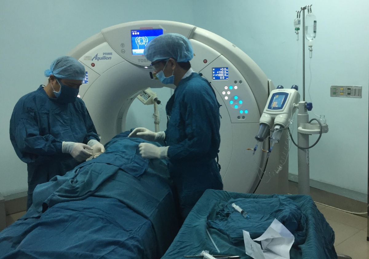 PGS- TS Bùi Văn Giang, cùng ê-kíp bác sĩ BVĐK tỉnh thực hiện các kỹ thuật điều trị giảm đau cho bệnh nhân - Ảnh Hoài Nam- Thanh Hải